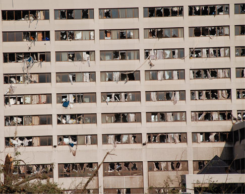 Debris visible through the broken windows of a multi-story building