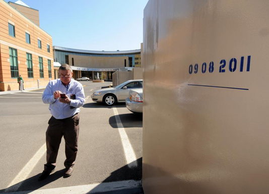 A FEMA supervisor documents the 09/08/2011 high water mark on Our Lady of Lourdes Memorial Hospital's flood wall.