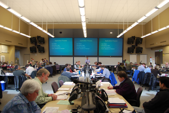 A FEMA official giving a presentation in a large conference room.
