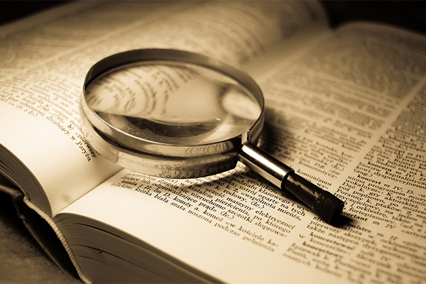 Magnifying glass over an open dictionary