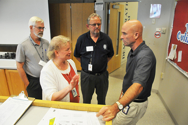 Four individuals talking at a National Flood Insurance Program meeting