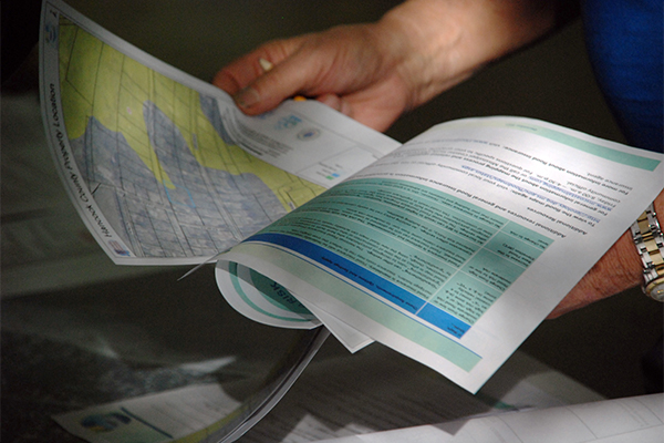 An individual holding a flood map and related information