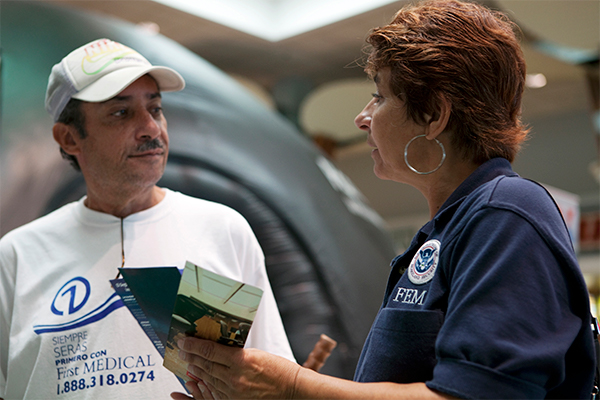 A member of the National Flood Insurance Program providing information to a survivor