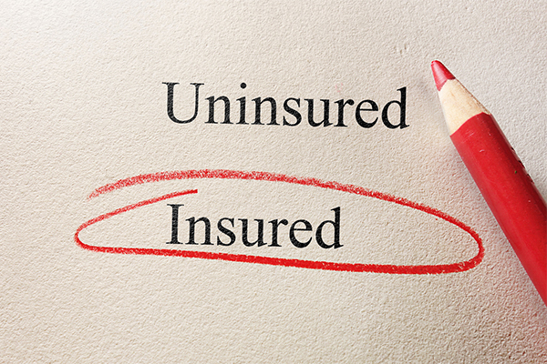 A paper with the word uninsured and the word insured, but the word insured is circled in red with a pencil next to it