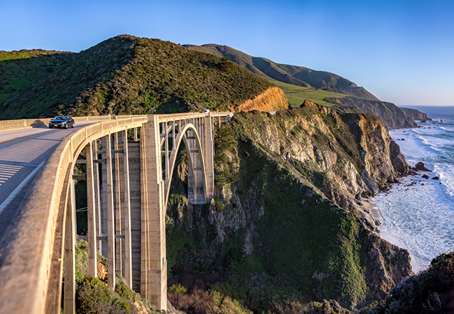 A bridge overlooking ocean and mountains.