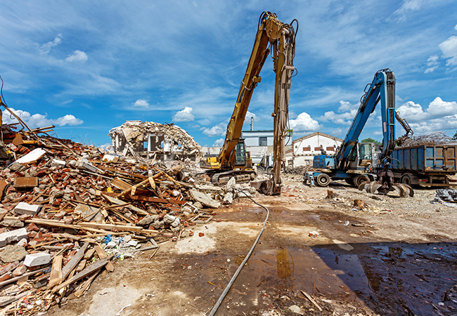 A bulldozer deconstructing a building.