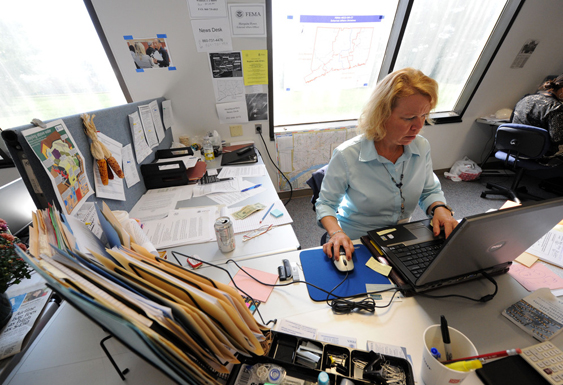 A person working at a computer in a large cubicle.