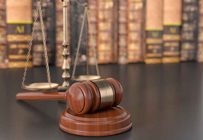 Gavel in front of a row of law books.