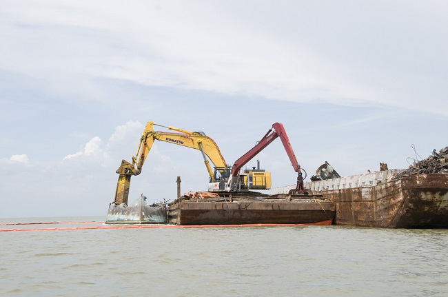 Heavy equipment assisting in debris removal in Galveston Bay.