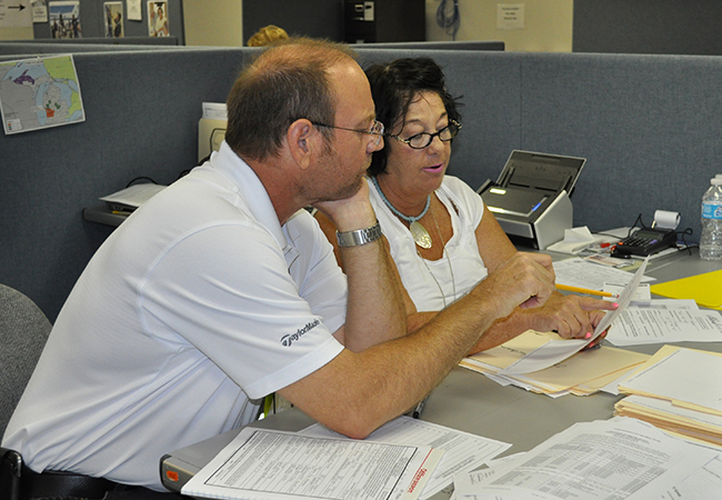 A FEMA Project Specialist reviews reports with a Public Assistance Crew Leader.