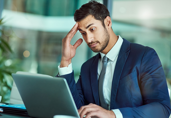 Businessman reviewing work on laptop