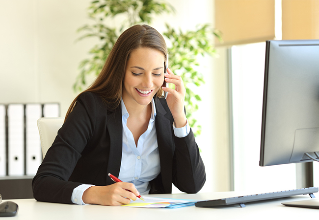 Business woman on a phone call taking notes