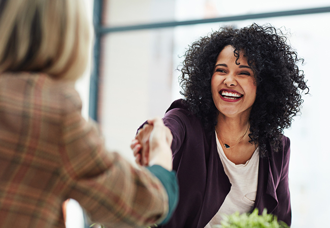 Two women shaking hands at a business meeting