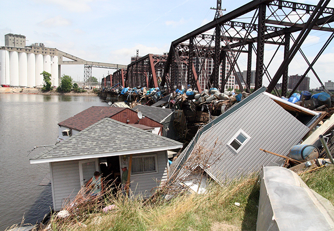 Tons of debris and homes piled against a bridge.