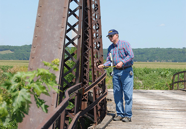 FEMA Public Assistance officer measures the amount of bridge displacement from flood waters of an 87-year-old historical bridge.