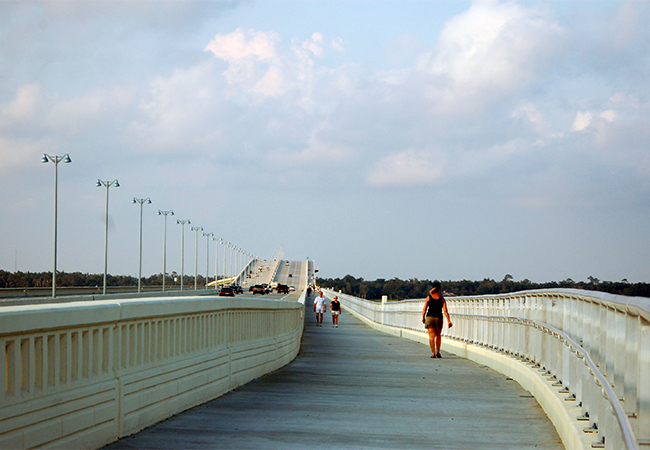 Joggers and motorists travel the Highway 90 Bridge that opened after the previous was destroyed by Hurricane Katrina.