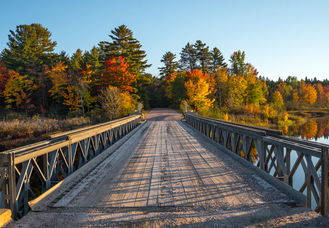 A single lane timber bridge over a lake