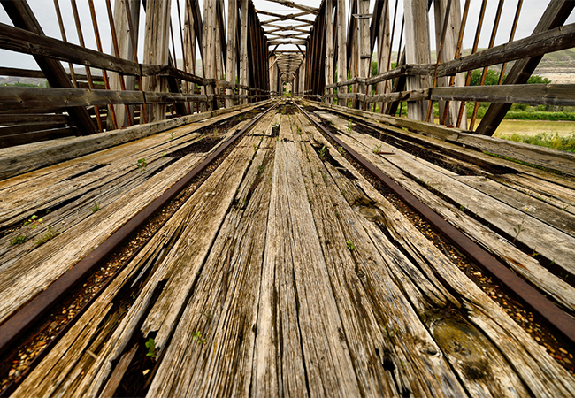 Old wooden bridge with rotting timbers.