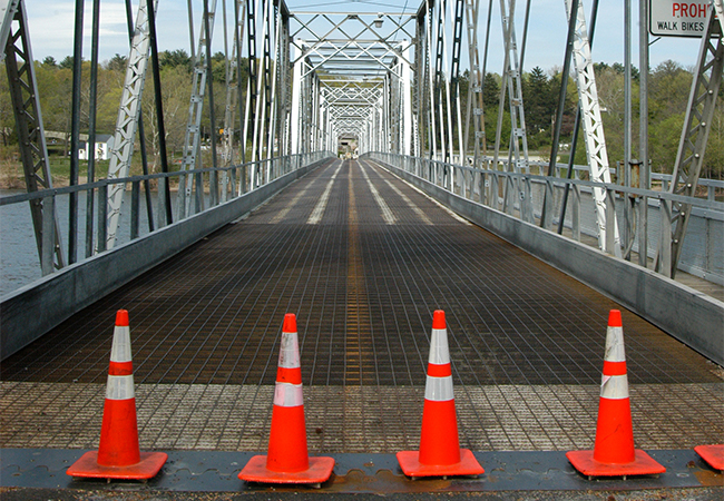 A vacant bridge with traffic cones.