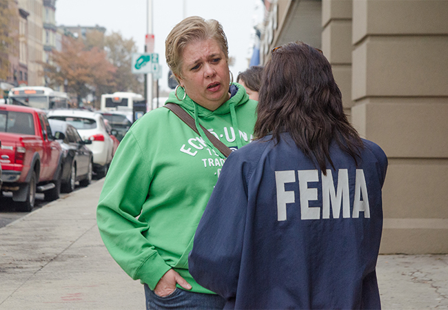 Applicant talking with FEMA personnel on the street