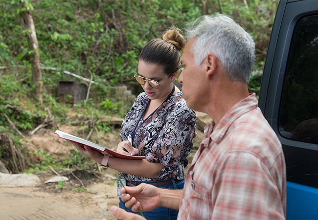 EHP employee writing while talking to survivor on a road