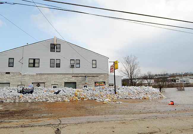 A business next to a river surrounded by sandbags.