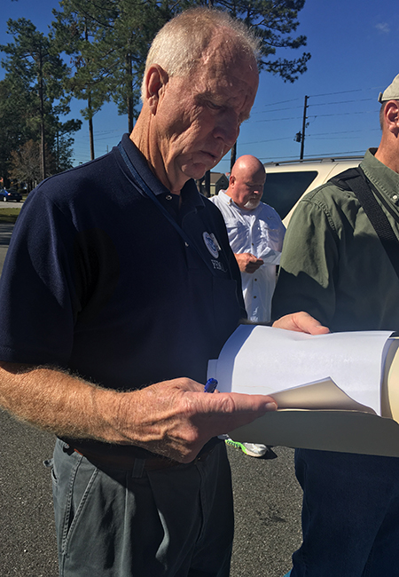 A FEMA Public Assistance site inspector verifying documentation at a facility.