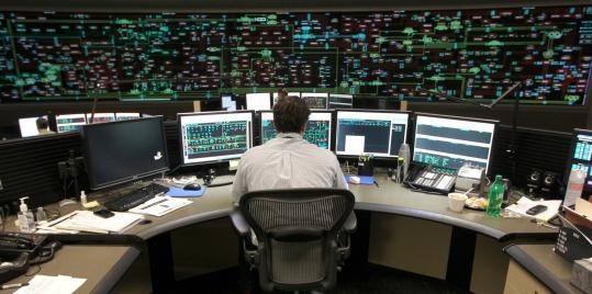 a dispatcher at a desk surrounded with computer screens