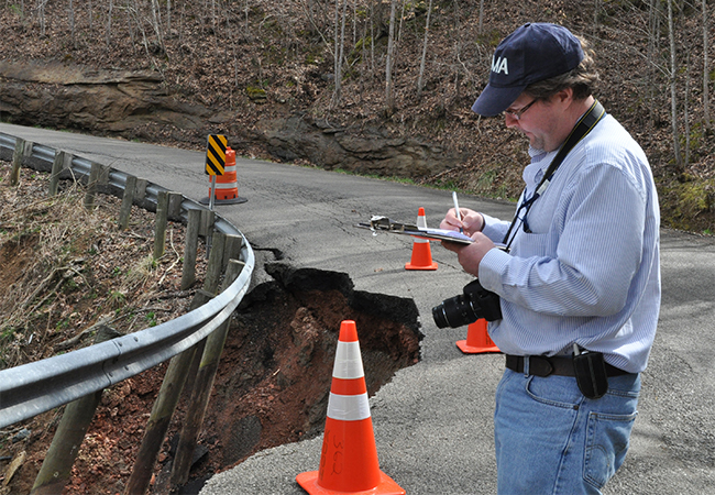 FEMA site inspector at a road washout.