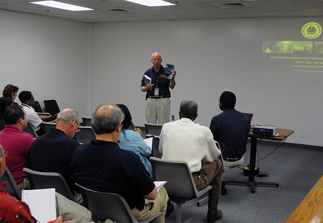 Mississippi Emergency Management Agency representatives at a meeting to brief attendees about FEMA Public Assistance funds.