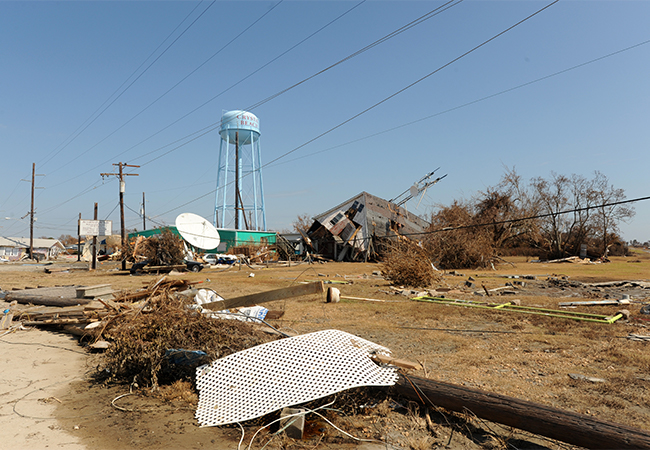 Debris and damaged houses along a major highway due to a hurricane.