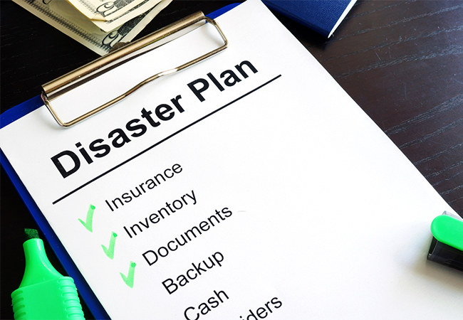 Disaster Plan on a clipboard on a table: Insurance, Inventory, Documents, Backup, Cash. There are green checkmarks next to Insurance, Inventory, and Documents.