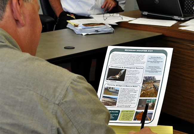 Applicant takes notes after reading the Public Assistance "Green Sheet."