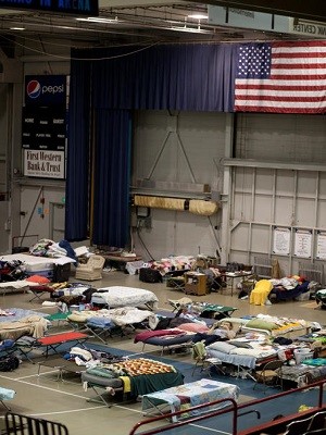 Individuals sleep on cots at a shelter in North Dakota.