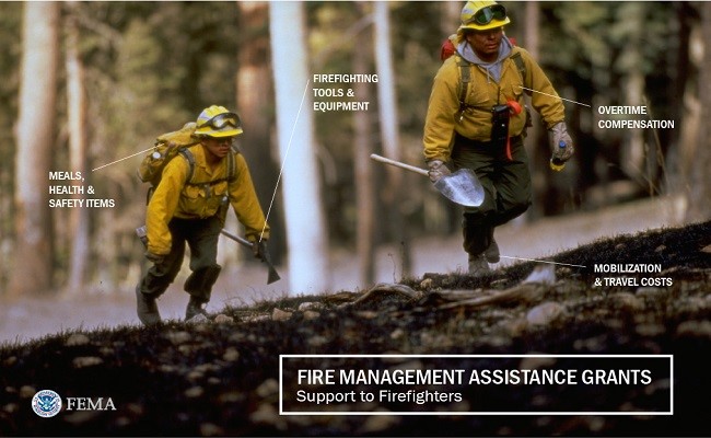 Firefighters walking with their tools, equipment, and safety items in their backpacks.