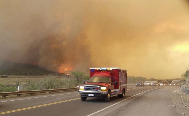 An ambulance passes a long line of residents evacuating West Glenwood, Colorado after the Coal Seam fire jumped the Colorado River.