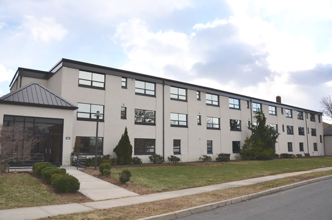 A photograph of a three-story condominium building
