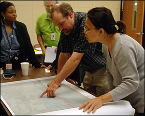 Biloxi floodplain manager Richard Stickler shows a flood map to Mai Trinh at a flood map meeting. FEMA/Jennifer Smits