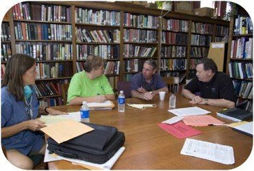 Local leaders meeting around a library table.